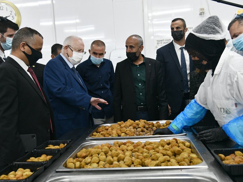 נשיא המדינה וראשי ציבור מבקרים במפעל ברהט המשלב נשים בדואיות בתעסוקה בשנת 2021; תצלום הקשרי שאינו מתעד רשות או משתתפת שנחקרו במאמר
