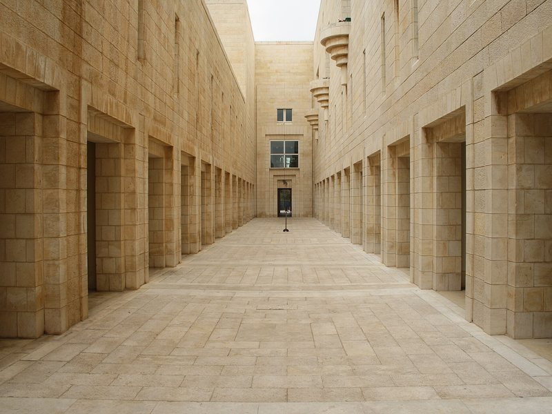 שופטים וחוקרים בוחנים דגם טופוגרפי מופשט של דרך, מכשול ומחצבה מול נציגי צבא ואזרחים, ללא מפה מזוהה או כיתוב