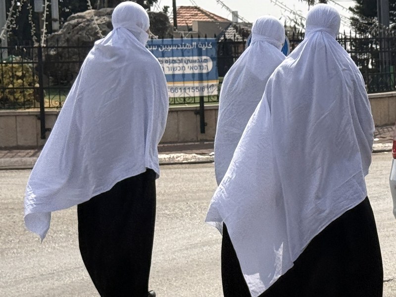 שלוש נשים דרוזיות בלבוש מסורתי הולכות יחד ברחוב ביישוב בישראל