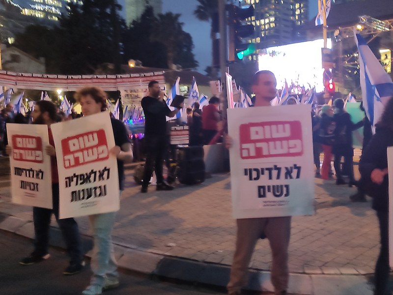מפגינים בתל אביב נושאים שלטים בעד שוויון ונגד השינויים במערכת המשפט במרץ 2023