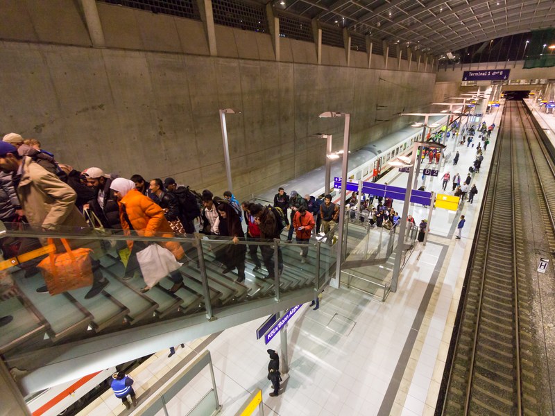 פליטים מגיעים ברכבת ועולים מן הרציף בתחנת נמל התעופה קלן־בון בספטמבר 2015