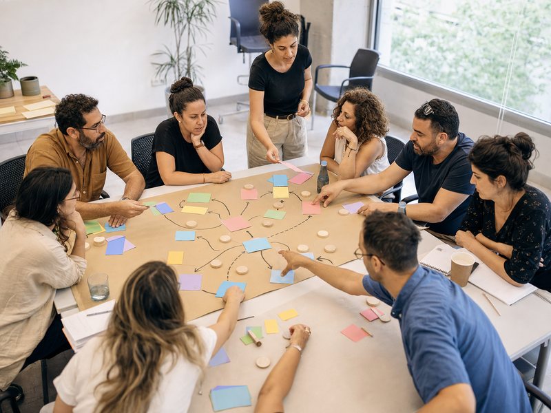 עובדות ועובדי ציבור מסדרים כרטיסים ואסימונים בסדנה מעשית למיפוי מדיניות