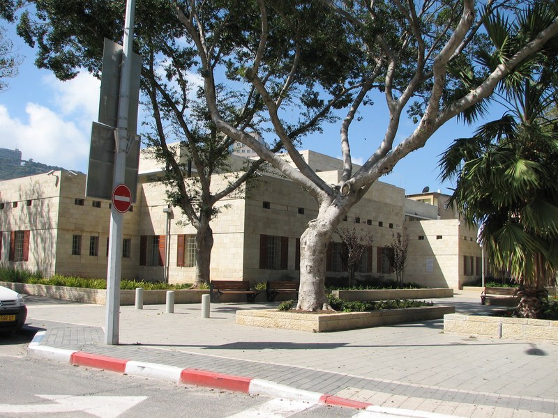 מבנה בית המשפט המחוזי הישן בחיפה מוקף עצים ורחבה ציבורית